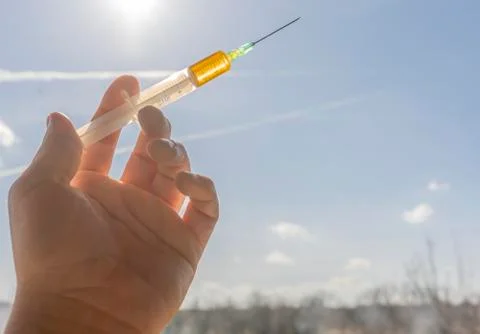 A syringe in the hand facing the sky Stock Photos