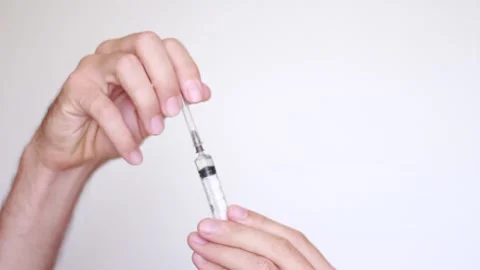 Syringe in hand white background 스톡 동영상 157355338