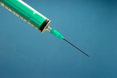 Syringe for injection on a blue background. Stock Photos