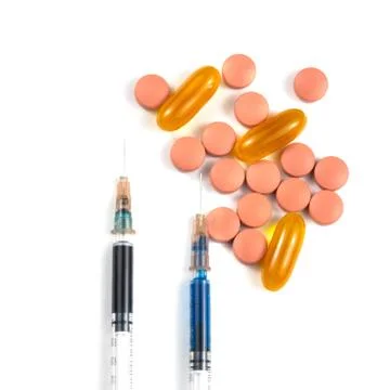 A syringe with an injection solution and vitamins with pills Stock Photos