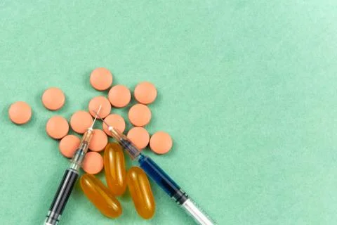 A syringe with an injection solution and vitamins with pills Foto stock