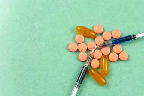 A syringe with an injection solution and vitamins with pills Foto stock