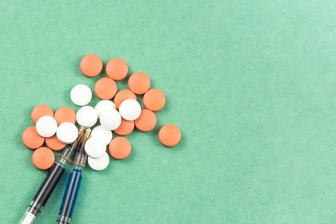 A syringe with an injection solution and vitamins with pills Foto stock