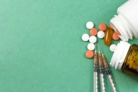 A syringe with an injection solution and vitamins with pills Foto stock