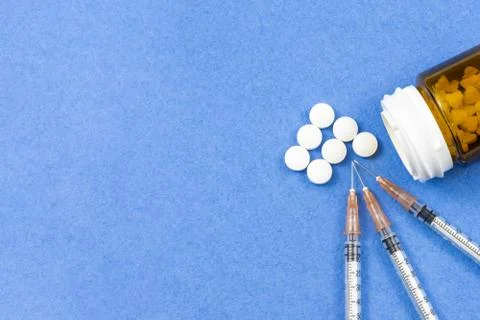 A syringe with an injection solution and vitamins with pills Foto stock