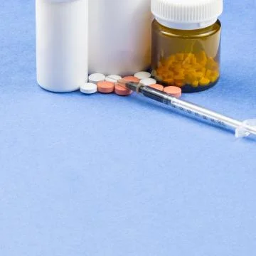 A syringe with an injection solution and vitamins with pills Foto stock