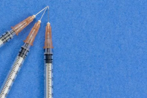 A syringe with an injection solution on a blue background Stock Photos