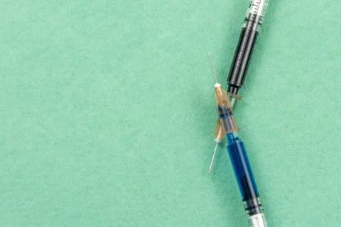 A syringe with an injection solution on green background Stock-Fotos