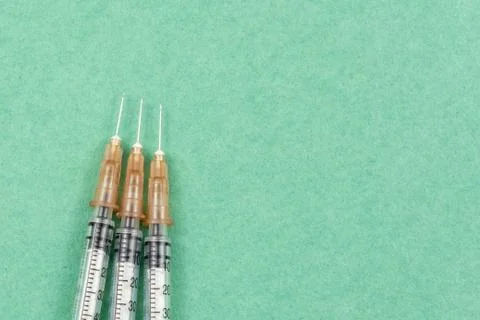 A syringe with an injection solution on green background Stock Photos