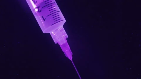 Syringe injects in a fluid with some bubbles at the ends. Sci fi Stock Footage 134551290