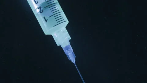Syringe injects in a fluid with some bubbles at the ends. Science fiction, medic Stock-Footage 134595508