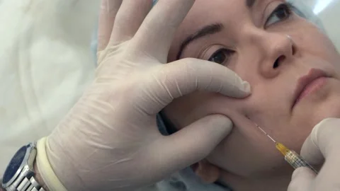 The syringe is inserted deep and is located under the muscle of the woman s Stock Footage 132217392