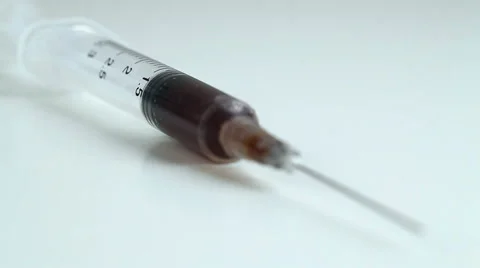 A syringe lying on a white table Vídeo Stock 58878883