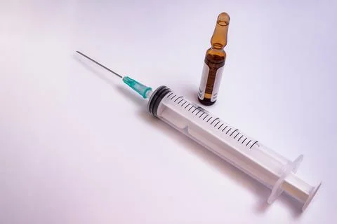 Syringe, needle and a medication vial on a white background Stock Photos