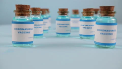 Syringe needle, a drop liquid, blurred pfizer company on the blue background. 库存影片 144606929