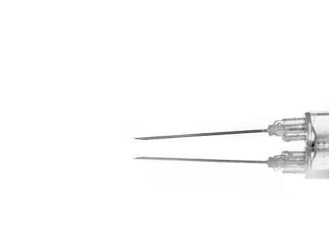 Syringe with needle on white background, reflection in the base - macro photo Stock Photos