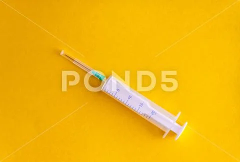 Syringe with a needle on a yellow background, is isolated. Copy space. Flat l Stock Photos