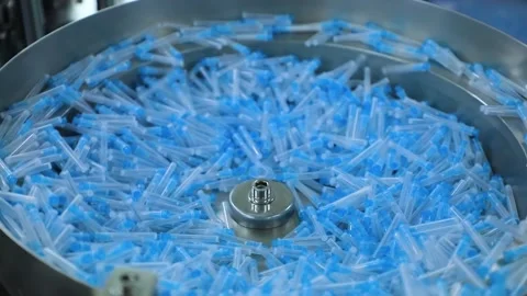 Syringe needles spin on a circular conveyor Stock Footage 163088100