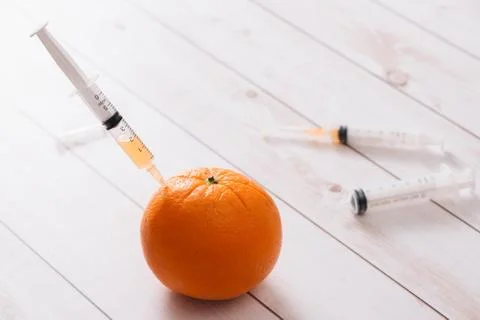 Syringe of orange on a white background isolation Stock Photos