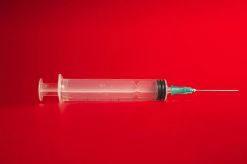 Syringe on a red background Fotos de archivo