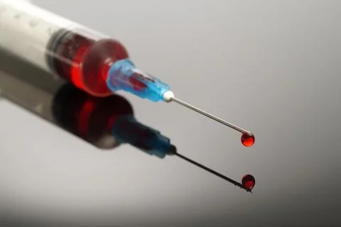 Syringe with red drop Stock Photos