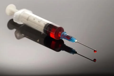 Syringe with red drop Stock Photos