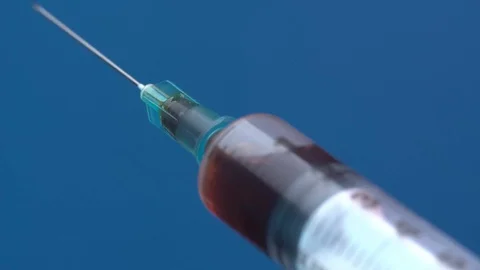 Syringe on a turntable blue background Video stock 128343397