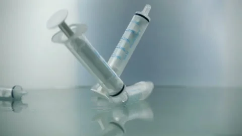 Syringes falling on blue background in slow motion. Prevention Immunization Stock Footage 171249492