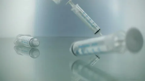 Syringes falling on blue background in slow motion. Prevention Immunization Stock Footage 171249493
