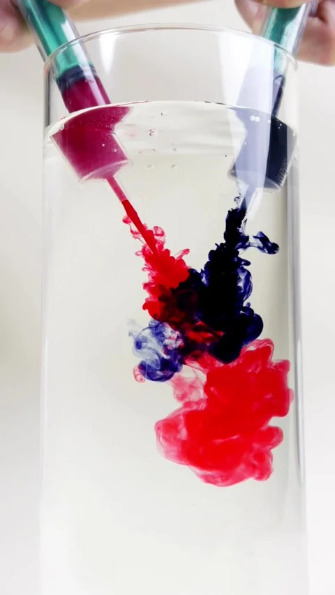 Syringes inject red and blue ink into clear water Stock-Footage 331774707