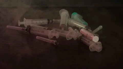 Syringes lie on the table in the smoke Stock Footage 156796093