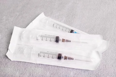 Syringes in a package on a gray background Stock Photos