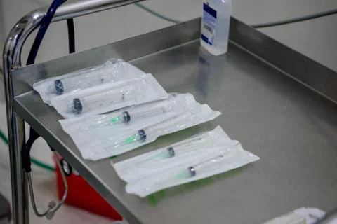 Syringes in packaging on a metal table in the operating room. Stock Photos