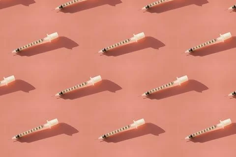 Syringes on a pink background seamless pattern. Stock Photos
