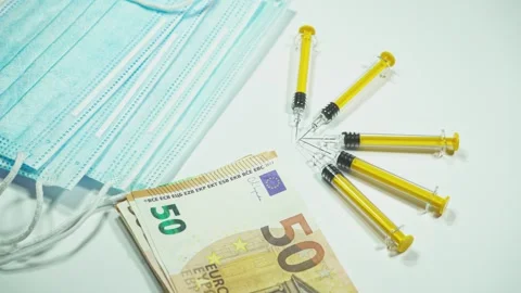 Syringes pointing at euro banknotes with face masks Stock Footage 295211900