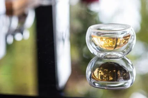 The syrup in clear cup on mirror surface with reflection. Stock Photos