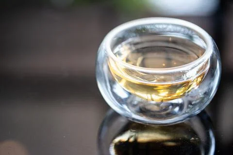 The syrup in clear cup on mirror surface with reflection. Stock Photos