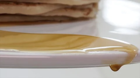 Syrup dripping down the side of a plate from pancakes Stock Footage 170605646