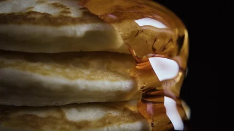 A syrup flows from the pancakes, close up on a black background Stock-Footage 75034408