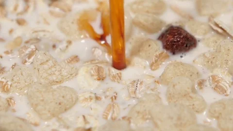 Syrup is poured in dry breakfast, slow motion. Close up Stock-Footage 76131961