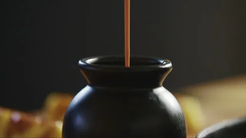 Syrup poured into small black container Stock Footage 274710329
