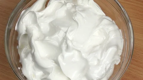 Syrup poured whipped thick white cream. Slow motion, top view Stock Footage 76135310