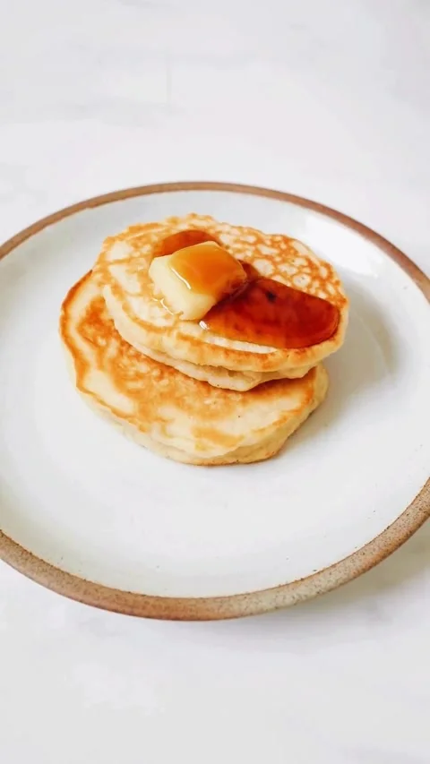 Syrup Pouring Over Fluffy Pancakes With Melting Butter On A Ceramic Plate Video stock 343471977