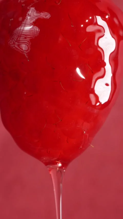 Syrup pouring over a raspberry berry, enveloping it, macro Stock Footage 308931133