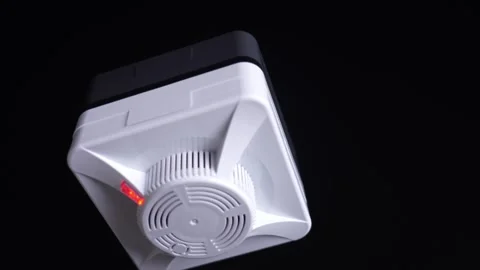 System activation: close-up of a white smoke detector on a matte black ceiling, Stock Footage 342397149