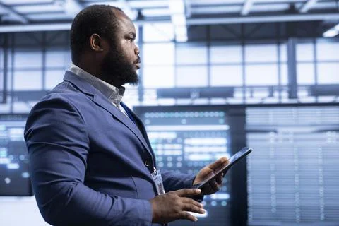 System administrator in data center checking rigs and hardware using tablet 스톡 사진