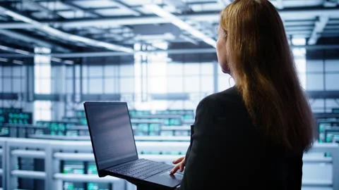 System administrator in data center running error checking utilities on laptop Stock Footage 277651376