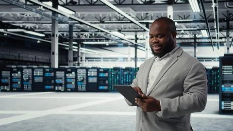 System administrator in data center workplace uses tablet to calibrate energy Stock Photos