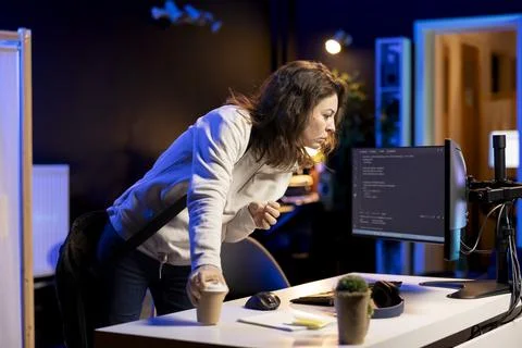 System administrator with disposable cup of coffee in home office Foto stock