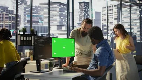 System administrator does software debugging on green screen PC with colleague 写真素材